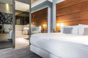 a bedroom with a large white bed and a mirror at Hilton Garden Inn Mannheim in Mannheim +44 photos