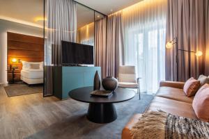 a living room with a couch and a tv at Hilton Garden Inn Mannheim in Mannheim