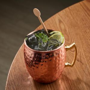 a copper cup with a drink on a wooden table at Hilton DoubleTree Bogotá Salitre AR in Bogotá