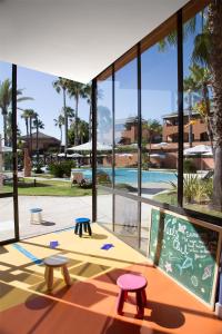 a room with a view of a pool and three stools at DoubleTree by Hilton Islantilla Beach Golf Resort in Islantilla +75 photos