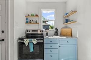 a kitchen with blue cabinets and a stove at Belote Place Bungalow in Jacksonville