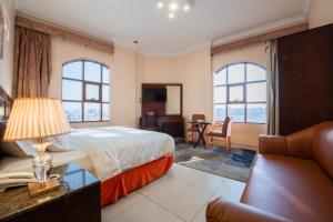 a bedroom with a bed and a table and chairs at Al Ayniah Hotel in Medina