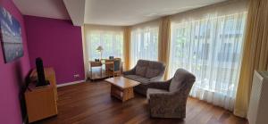 a living room with two chairs and a tv at Bel Sole Badenweiler in Badenweiler