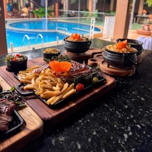a table with a tray of food and french fries at Village Park Hotel in Pires Ferreira