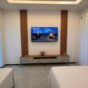 a flat screen tv on a wall in a room at Village Park Hotel in Pires Ferreira