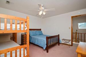a bedroom with two bunk beds and a ceiling fan at The Rectory by Oak Island Accommodations in Oak Island