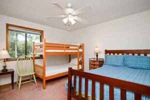 a bedroom with a bunk bed and a ceiling fan at The Rectory by Oak Island Accommodations in Oak Island
