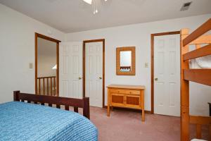 a bedroom with a bed and a dresser and a mirror at The Rectory by Oak Island Accommodations in Oak Island