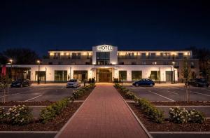 a hotel building with a parking lot at night at Hotel Ks in Bad Fallingbostel