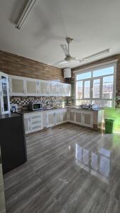 a large kitchen with white cabinets and a wooden floor at Rosa mountain reast in Al ‘Aqar