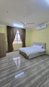 a bedroom with a bed and a large window at Rosa mountain reast in Al ‘Aqar +21 photos