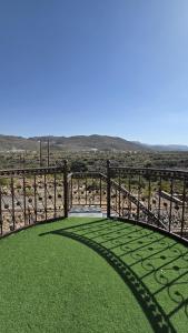 a fence with green grass in the middle of a field at Rosa mountain reast in Al ‘Aqar