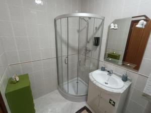 a bathroom with a shower and a sink at Cantinho da Xica in Lagos +7 photos