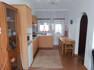 a kitchen with a table and a dining room at Cantinho da Xica in Lagos
