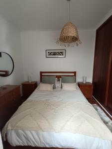 a bedroom with a bed and a chandelier at Cantinho da Xica in Lagos