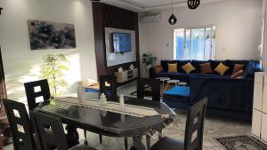 ein Wohnzimmer mit einem Tisch und einem blauen Sofa in der Unterkunft Djerba Aldo Piscine in Houmt Souk