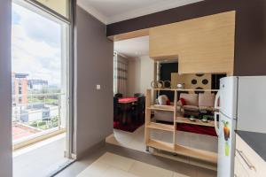 a kitchen with a refrigerator and a large window at IZA Serene city centre apartments in Kigali