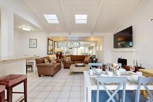 a living room with a couch and a table with chairs at Relaxation Station in Corona del Mar