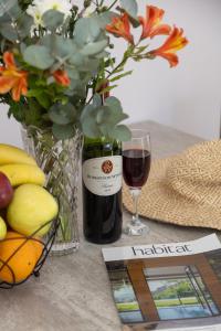 a bottle of wine next to a glass of red wine at Stunning Ocean & Mountain View Apartment in Glencairn +4 photos