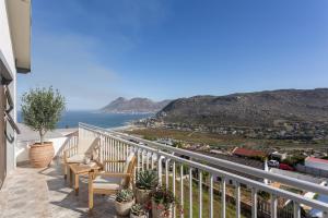 a balcony with chairs and a view of the ocean at Stunning Ocean & Mountain View Apartment in Glencairn