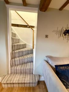 a staircase in a room with a striped stair case at George Cottage, Alcester in Alcester +15 photos