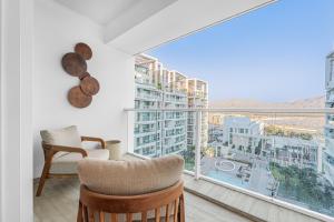 a room with a balcony with a view of a city at Redsearent front Pool and mountain View in Eilat