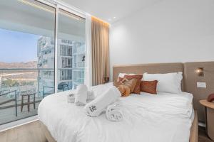 a bedroom with a bed and a large window at Redsearent front Pool and mountain View in Eilat