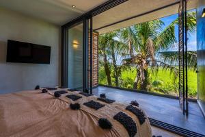 a bedroom with a large window with a large bed at Luxury Beachfront 3BR Apt 102 | Neea Bahia Soliman in Balcheil