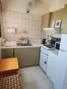 a small kitchen with a sink and a stove at Profelia Sea View Apartment in Paralimni +12 photos