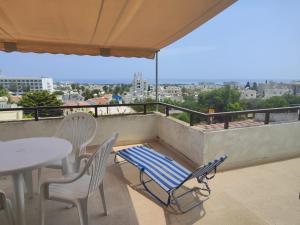 a table and chairs on a balcony with a view at Profelia Sea View Apartment in Paralimni