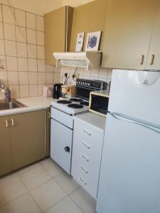 a kitchen with white appliances and a white refrigerator at Profelia Sea View Apartment in Paralimni