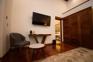 a living room with a chair and a table and a television at Mirtala Hotel Boutique in Guanajuato +22 photos
