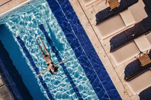 a man swimming in a swimming pool in a swimmingpool at HOTEL VILLE LA PLAGE & BEACH CLUB in Búzios