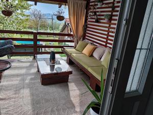 a screened in porch with a couch and a table at ZOĆEVIĆA KONAK in Petrovići +39 photos