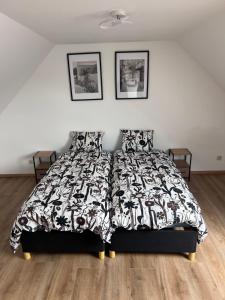 a bedroom with a bed with a black and white bedspread at Victoria Prestige Parking Gratuit in Boussu