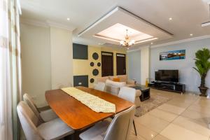 a dining room and living room with a table and chairs at IZA Serene city centre apartments in Kigali