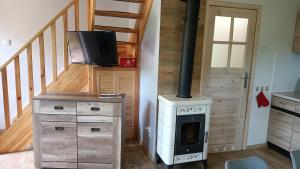 a living room with a stove and a staircase at Domek Anusia in Brożówka +18 photos