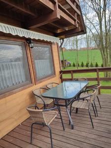 a patio with a table and chairs on a deck at Domek Anusia in Brożówka