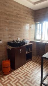 a kitchen with a stove in the middle of a room at Rehoboth place in Awoyaya
