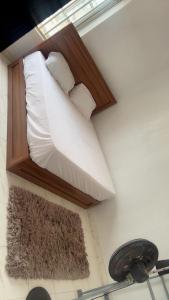 a bed with white sheets and pillows on a wall at Rehoboth place in Awoyaya