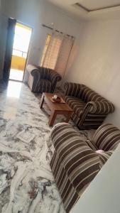 a living room with two couches and a coffee table at Rehoboth place in Awoyaya