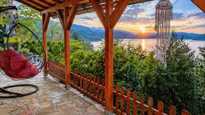 a porch with a view of the water and mountains at Smart Nature in Donji Milanovac