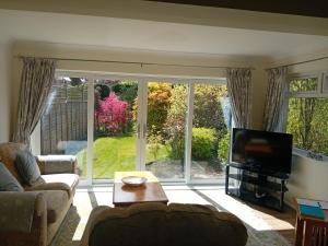 a living room with a large sliding glass door at Abbeyside Cottage in Kelso +9 photos