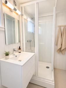 a white bathroom with a shower and a sink at Nordic Studio - Gravdal, Lofoten in Haug