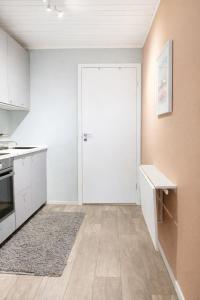 a kitchen with white cabinets and a white door at Nordic Studio - Gravdal, Lofoten in Haug