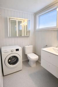 a bathroom with a washing machine and a toilet at Nordic Studio - Gravdal, Lofoten in Haug
