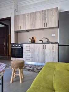 a kitchen with wooden cabinets and a stool in a room at Mok's House in Kavála