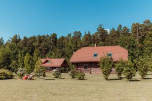 a log cabin with people sitting outside of it at Silmaļi Tērvetē in Tērvete