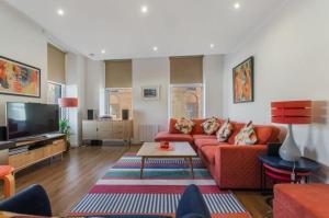a living room with a red couch and a tv at Blackfriars Cosy Retreat in Glasgow