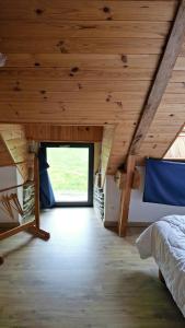 a bedroom with a bed and a vaulted ceiling at Charmante longère forestière proche Lac de Guerlédan in Sainte-Brigitte